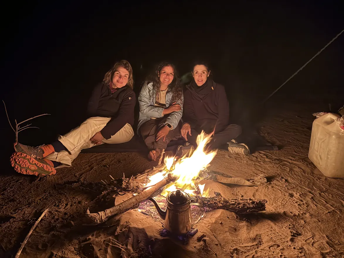 מטיילות סביב מדורה בלילה במדבר